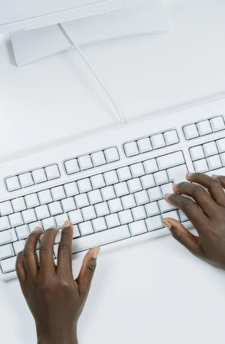 Hands typing on a white keyboard while planning digital marketing strategies for SaaS businesses and online content creation